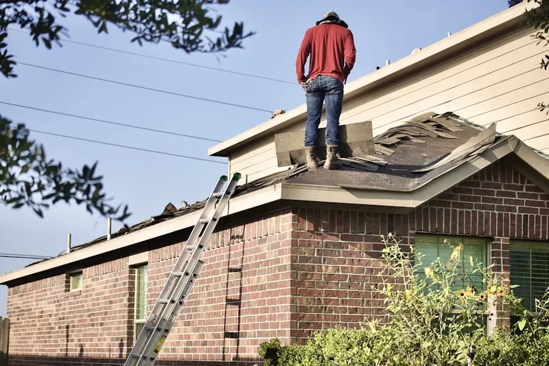 Professional roofer working on a residential roof in Robinsville